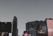 ‘웰빙의 비결, 꾸준한 걷기 생활’… 일상 속 걷기 습관으로 건강 챙기기 a woman wearing a face mask walking down a street