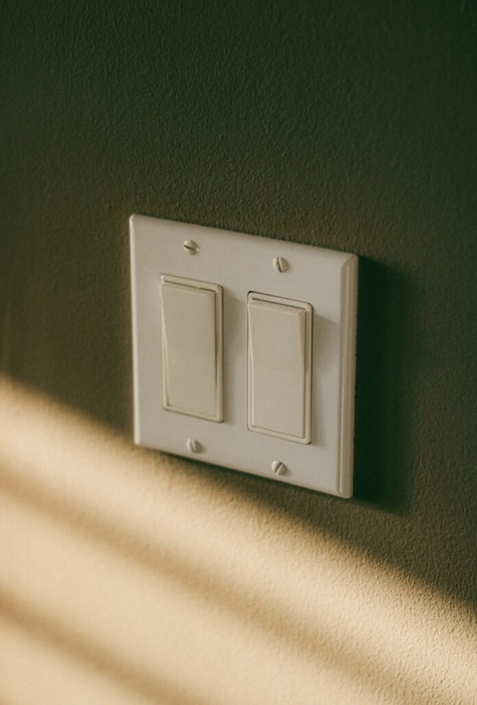 Photo by Linus Belanger a white light switch sitting on top of a wall