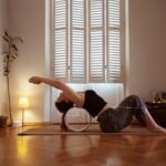 일상 속 활력 불어넣는 필라테스, 집과 직장에서 실천하는 건강 루틴 A woman is doing a yoga pose on a mat