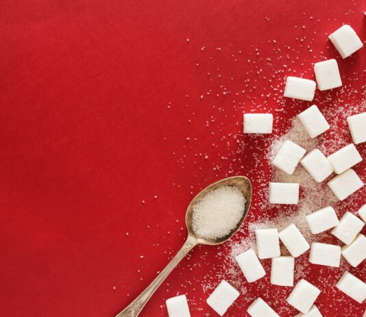 “설탕 대신 먹었는데”… 제로 열풍의 주역 ‘알룰로스’의 배신? 오해와 진실 sugar cubes and a spoon on a red surface