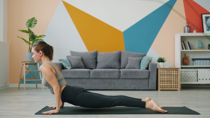 Woman doing upward-facing dog yoga pose on mat