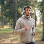 러닝 후 회복의 기술: 잘 쉬는 것도 ‘훈련’의 일부다 Man with headphones running in a forest