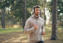 러닝 후 회복의 기술: 잘 쉬는 것도 ‘훈련’의 일부다 Man with headphones running in a forest