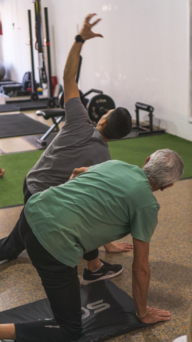 Photo by Federico Faccipieri a couple of men standing on top of a yoga mat