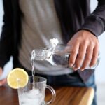 수분의 과학: “하루 2리터?” 내 몸에 필요한 진짜 수분량과 똑똑하게 물 마시는 법 man pouring water in glass