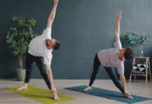 남자와 요가(Men’s Yoga): “유연해야 할 수 있다?” 편견을 깨고 남성이 요가 매트에 서야 하는 이유 Couple practicing yoga in a modern room.