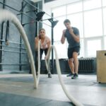 짧고 굵게, ‘고강도 인터벌 운동’이 일상 속으로 Man and woman exercising with battle ropes.