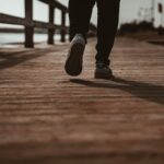 하루 한 번, 짧은 산책이 부르는 건강 혁신—“걷기 습관”이 만드는 변화 person in black pants and black shoes standing on brown wooden dock during daytime