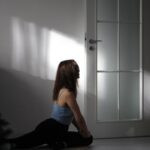 필라테스, 건강한 일상 속 새로운 즐거움으로 자리잡다 a woman sitting on the floor in front of a door