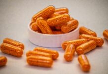 비타민과 영양제: “다 먹어야 할까?” 운동인이 꼭 챙겨야 할 필수 영양소 Top 3 Orange capsules filled with small beads spill from container.