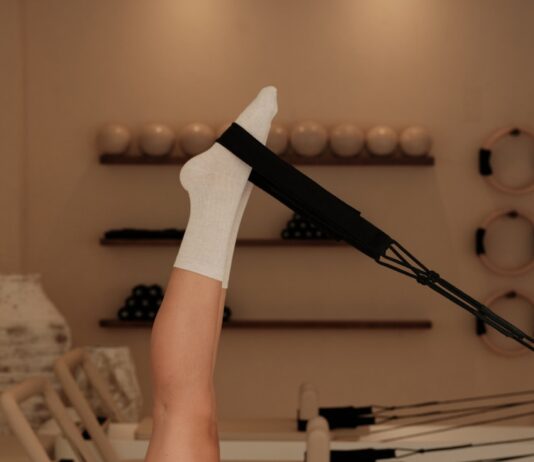 집에서도 즐기는 ‘필라테스 열풍’… 바쁜 일상 속 새로운 건강 루틴으로 인기 Woman does pilates exercise on a reformer machine.