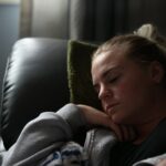 “수면 루틴 바꾸니 삶이 달라졌다”…실생활 속 꿀잠 실천법 boy in gray hoodie lying on black leather couch