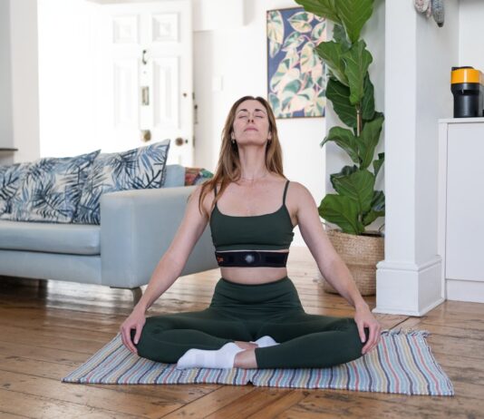 웰니스 문화, 일상 속에서 스며드는 건강 트렌드 a woman sitting on a yoga mat in a living room