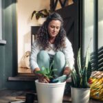 달라지는 스트레스 관리법, 소소한 일상 습관으로 지키는 마음 건강 Woman potting a plant on a porch