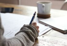 일상에서 실천하는 웰니스 문화, 작은 변화가 건강을 부른다 person writing on brown wooden table near white ceramic mug