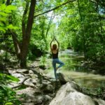 필라테스, 내 몸과 마음을 단련하는 생활 속 건강 습관으로 주목 woman in blue tank top and blue leggings standing on gray rock near river during daytime