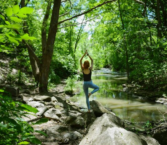 필라테스, 내 몸과 마음을 단련하는 생활 속 건강 습관으로 주목 woman in blue tank top and blue leggings standing on gray rock near river during daytime