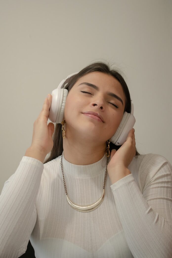Photo by Jair Medina Nossa a woman with her eyes closed holding a phone to her ear