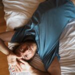 “내 마음 건강도 챙기자” 일상 속 실천으로 지키는 정신건강 트렌드 a man laying on top of a bed next to a wooden floor