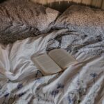 “마음 챙김, 일상에 녹이다…지속 가능한 스트레스 관리법” an open book is laying on a messy bed