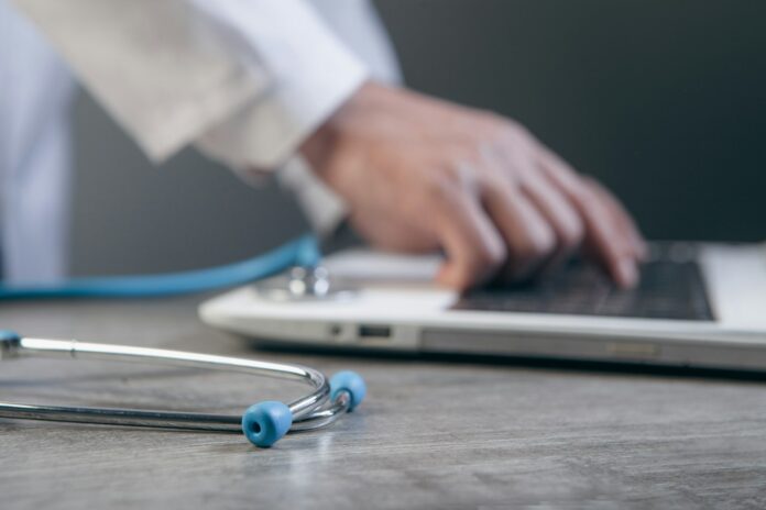 Photo by Sasun Bughdaryan Doctor typing on a laptop with a stethoscope nearby.
