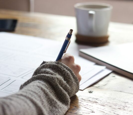 “끊이지 않는 피로감, ‘만성피로’ 극복하는 생활 속 작은 변화” person writing on brown wooden table near white ceramic mug