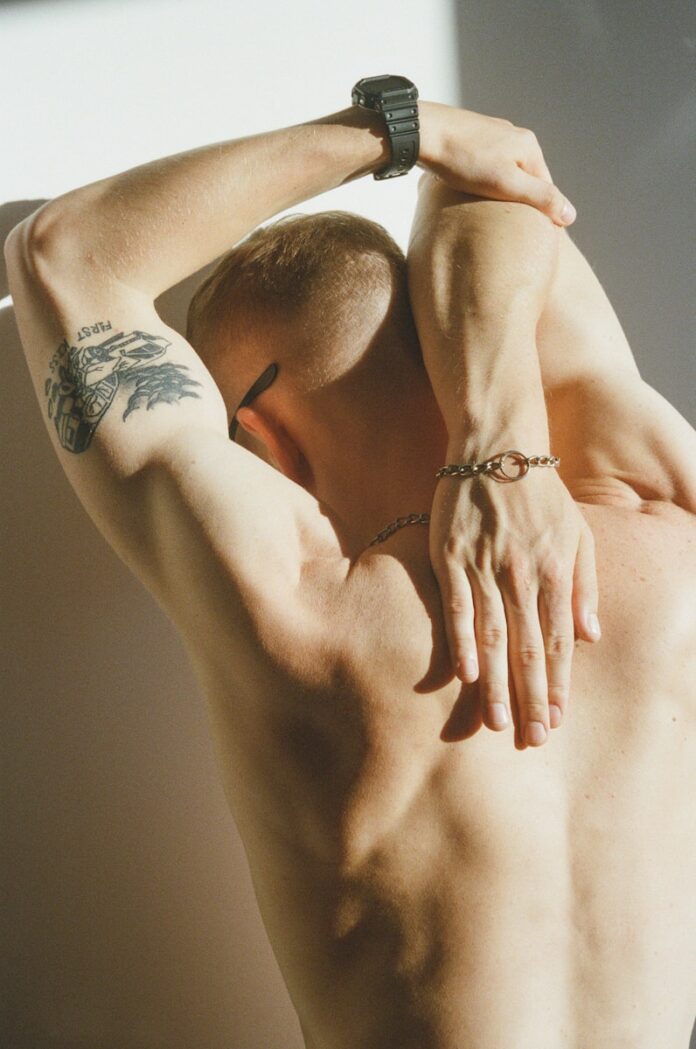 Photo by Sasha Lebedeva topless man with black tattoo on his back