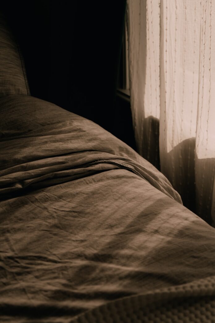 Photo by Anastasia Meraki A bed sitting next to a window in a bedroom