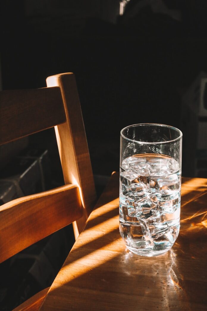 Photo by Giorgio Trovato clear drinking glass on brown wooden chair
