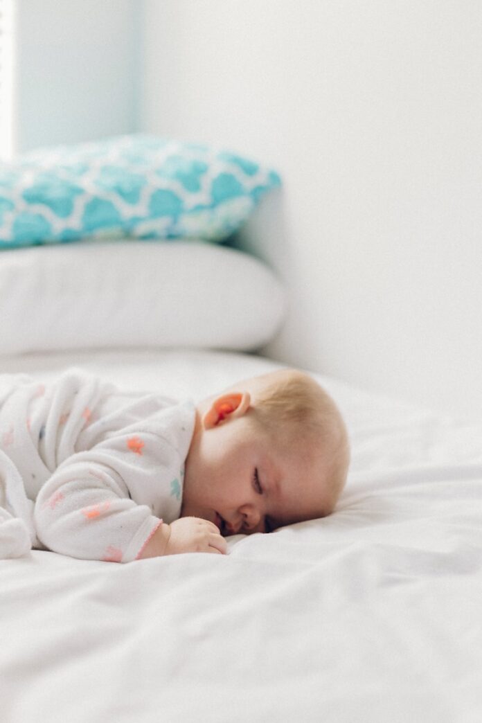 Photo by Dakota Corbin photo of baby laying on bed