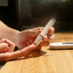 혈당관리에 스마트하게 접근하는 법, 당신의 생활을 바꿉니다! a person sitting at a table with a cell phone