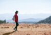 MZ세대부터 시니어까지, ‘마음챙김 걷기’로 삶의 질 높이기 a man with a backpack walking across a dry grass covered field