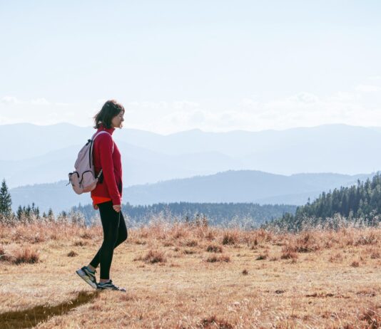 MZ세대부터 시니어까지, ‘마음챙김 걷기’로 삶의 질 높이기 a man with a backpack walking across a dry grass covered field