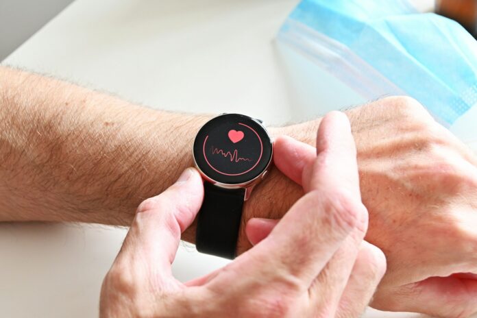 A person checking a heart rate monitor on a smartwatch on their wrist