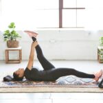 웰니스 회복, 현대인의 필수 건강 전략으로 떠오르다 woman in black tank top and black leggings lying on black and white floral area rug