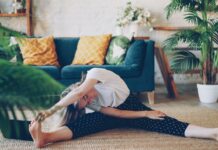 아침 루틴, 건강을 바꾸다… “작은 습관부터 시작하세요” Woman stretching on floor in a living room.