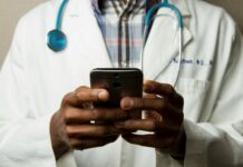 디지털 헬스케어, 손안의 건강관리 혁명 person wearing lavatory gown with green stethoscope on neck using phone while standing