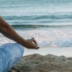집에서 쉽게 실천하는 ‘마음챙김 명상’, 스트레스 줄이고 일상 활력 높인다 person in blue shorts sitting on beach shore during daytime