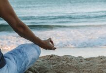집에서 쉽게 실천하는 ‘마음챙김 명상’, 스트레스 줄이고 일상 활력 높인다 person in blue shorts sitting on beach shore during daytime
