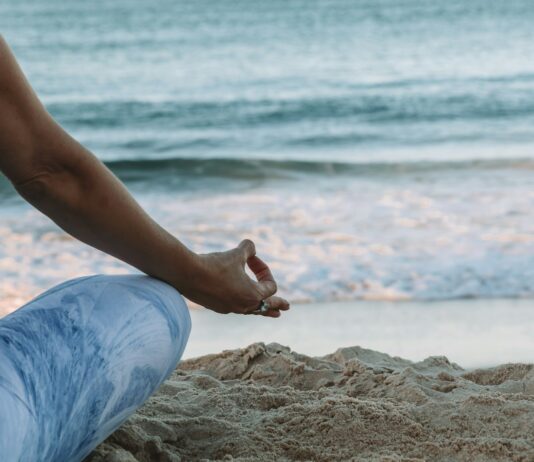 집에서 쉽게 실천하는 ‘마음챙김 명상’, 스트레스 줄이고 일상 활력 높인다 person in blue shorts sitting on beach shore during daytime