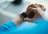 “웨어러블 데이터가 주도하는 건강관리 혁명: 손목에서 시작되는 일상 속 건강 비결” person clicking Apple Watch smartwatch