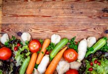 장 건강 개선, 이제 실천 가능한 방법으로 시작하세요 Fresh colorful vegetables arranged on a rustic wooden background.