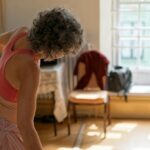 ‘마이크로 운동’이 부상한다… 바쁜 일상 속 건강 챙기는 새로운 습관 Woman with grey hair stretching in a sunlit room
