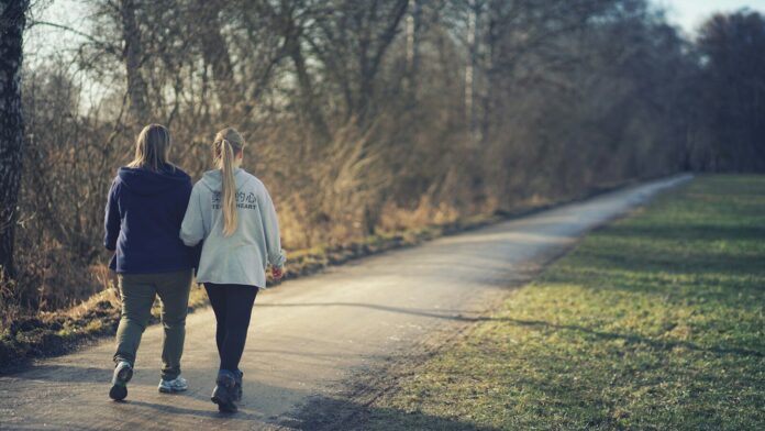 Photo by Johannes Plenio woman in white jacket and black pants walking on road during daytime