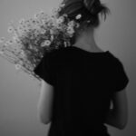직장인 ‘마음 챙김 루틴’, 현명하게 일상에 녹이기 A person in a black shirt holding a bouquet of daisies
