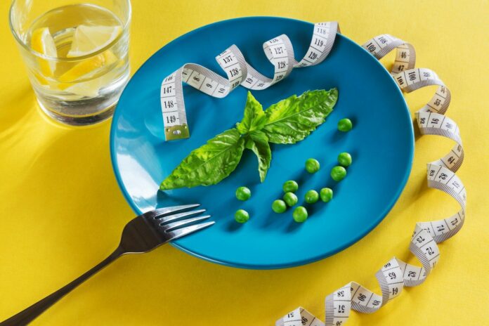 Photo by Elena Leya a blue plate topped with green vegetables and measuring tape