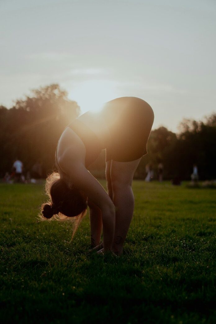 Photo by Chuko Cribb woman in white bikini bottom kneeling on green grass field during sunset