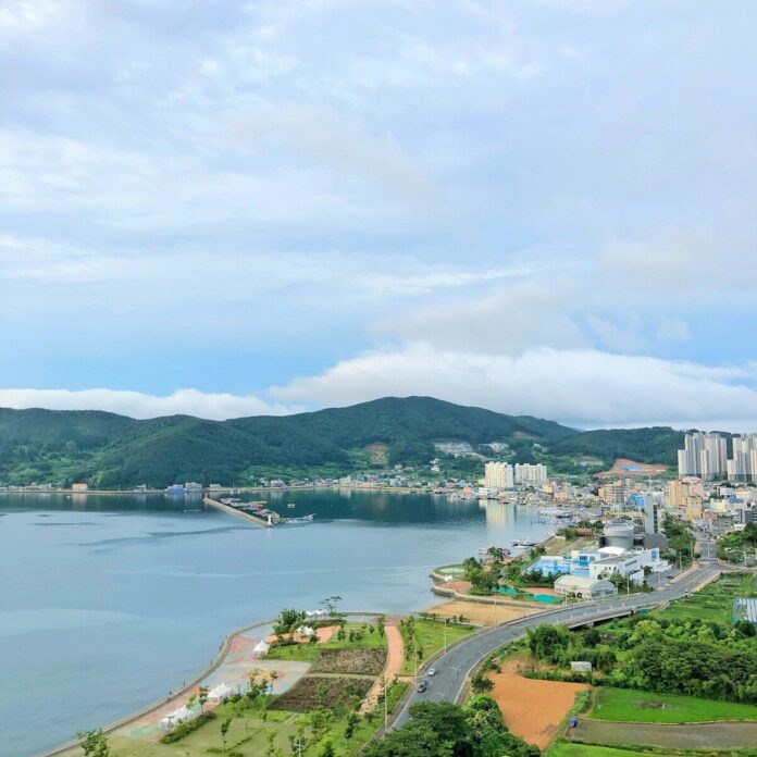 Photo by Huiii city buildings near body of water under white clouds during daytime