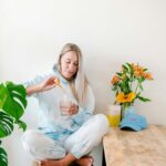 “하루 10분, 똑똑하게 건강 챙기기”…웰니스 루틴이 바꾸는 일상 a woman sitting on a stool holding a drink
