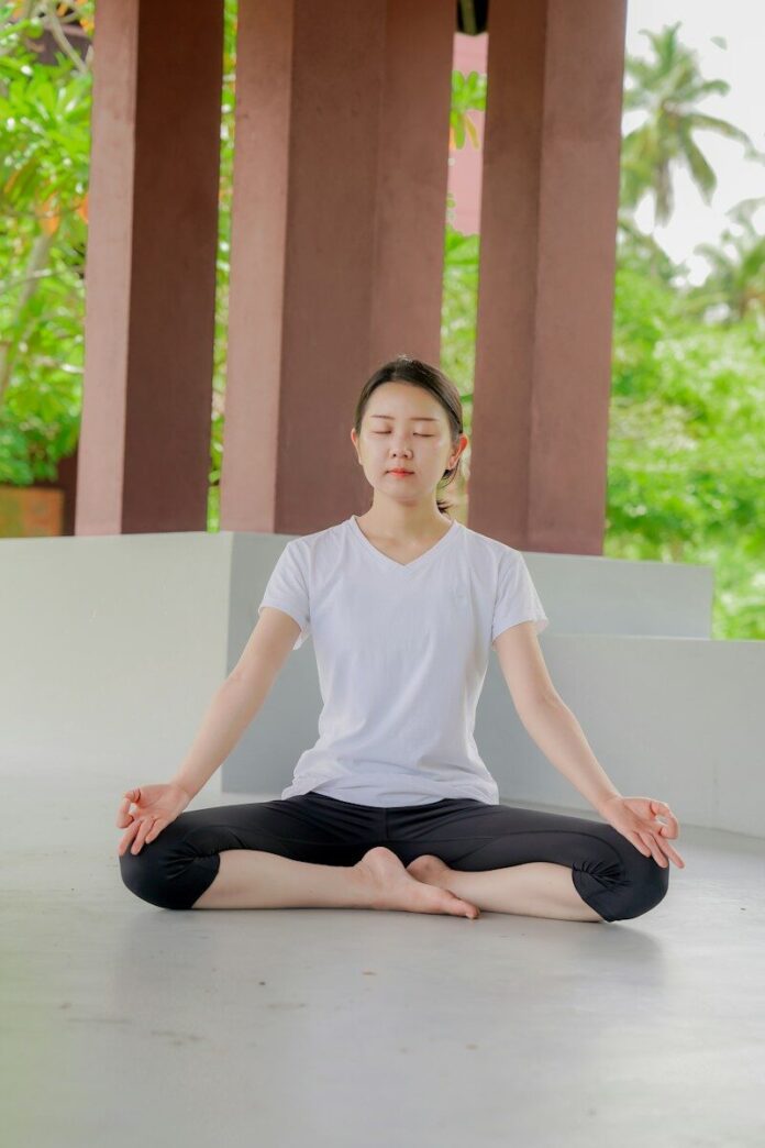 a woman is sitting in a lotus position